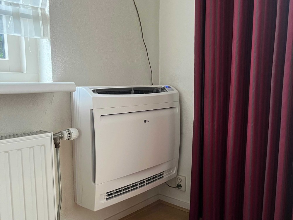 LG vloermodel airco in woonkamer Naaldwijk naast radiator door KW Airconditioning