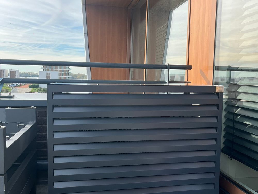 Buitenunit op appartement balkon in Rotterdam met antraciet lamellen omkasting