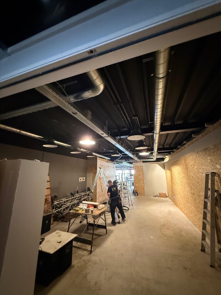 KW monteur installeert spirobuizen aan industrieel plafond in bedrijfspand