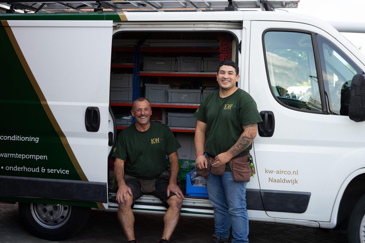 Twee monteurs van KW Airconditioning bij de servicebus